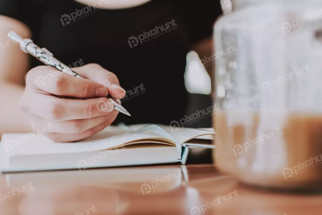 Free Premium Stock Photos A close-up of a woman's hand writing in a journal