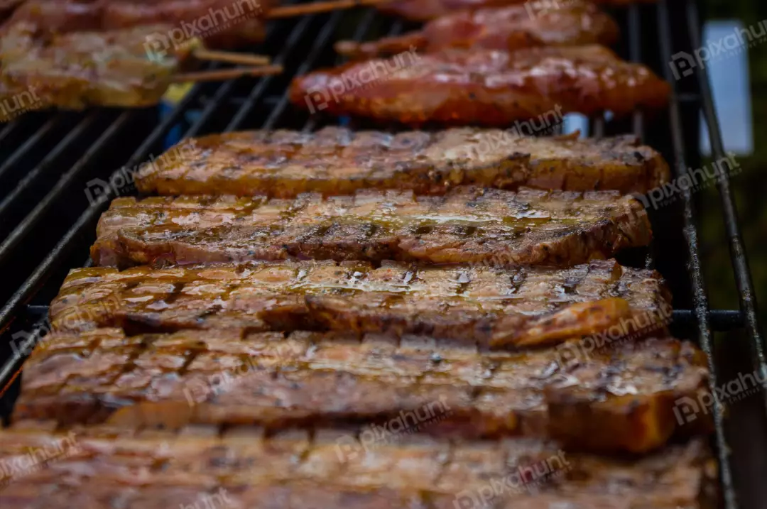 Free Premium Stock Photos Close-up of a grill with strips of bacon and pieces of meat on it