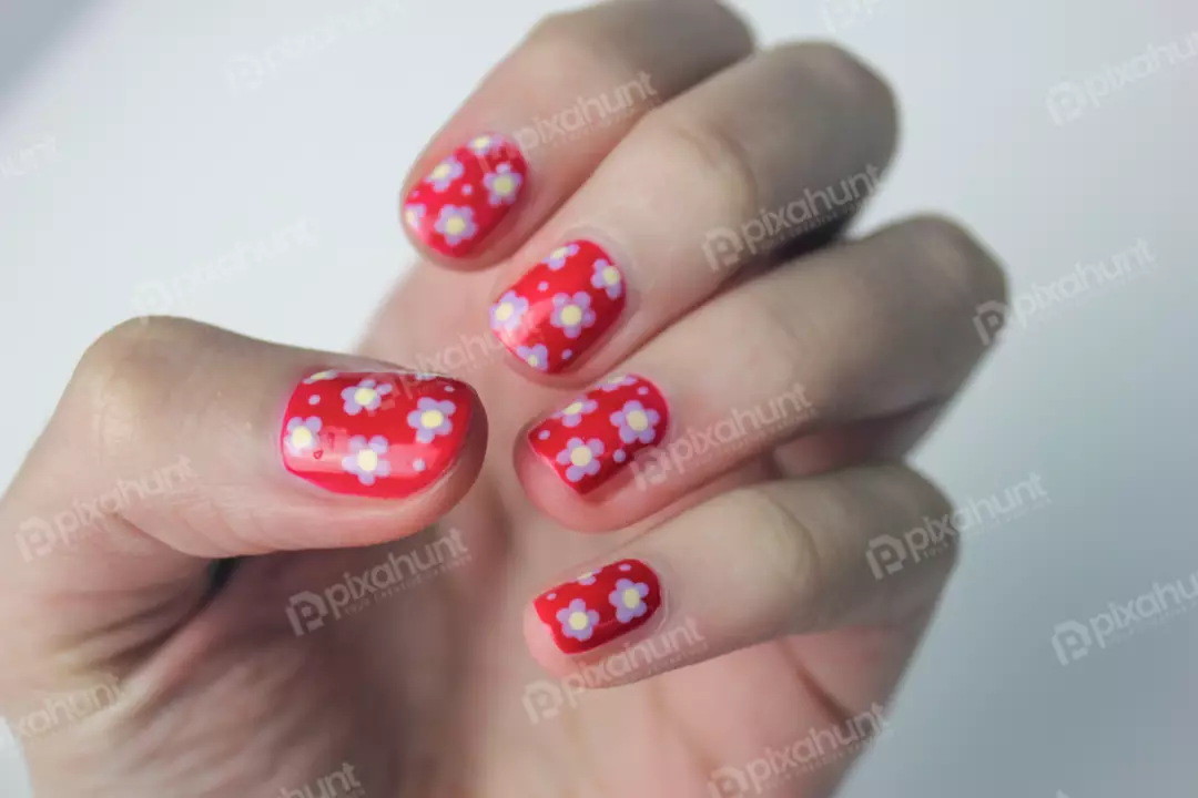 Free Premium Stock Photos A hand with a red nail polish with a floral pattern