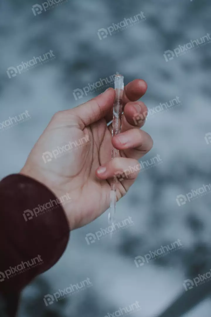 Free Premium Stock Photos a close-up of a hand holding a long, thin icicle