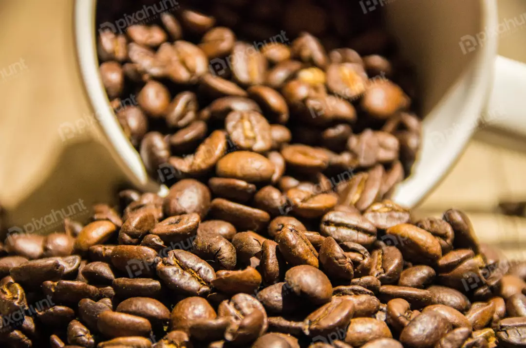 Free Premium Stock Photos A close-up of a pile of coffee beans spilling out of a white cup