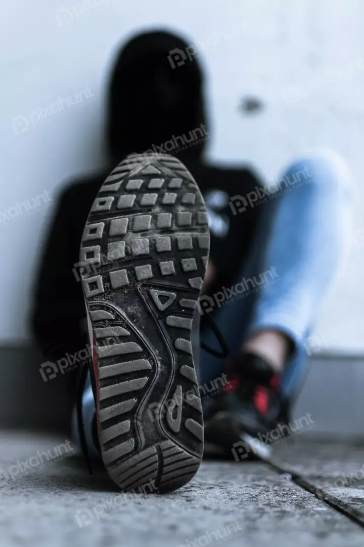 Free Premium Stock Photos Person is sitting on a concrete floor feet are crossed at the ankles