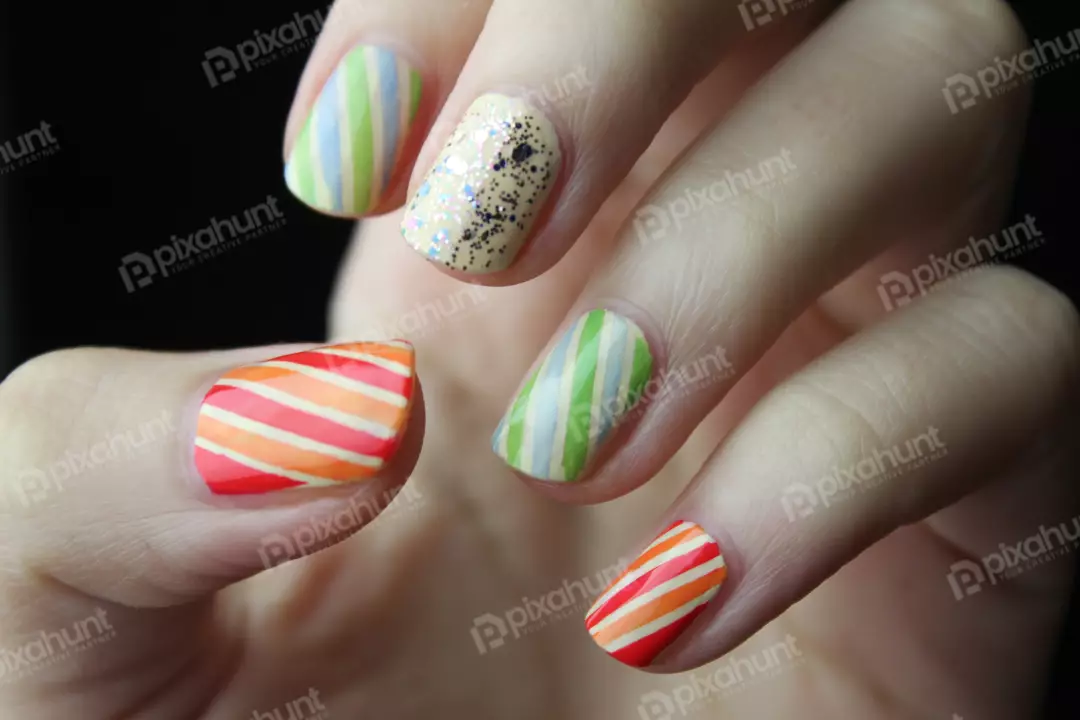 Free Premium Stock Photos A close-up of a hand with a colorful striped manicure