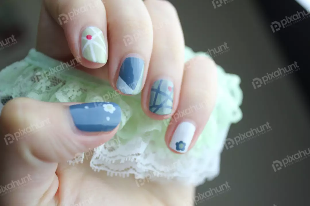 Free Premium Stock Photos A close-up of a hand with a blue and white nail art design