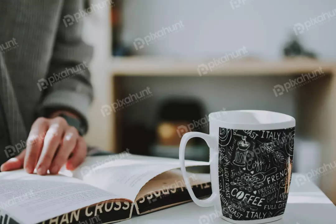 Free Premium Stock Photos table is made of wood, and there is a coffee mug on the table next to the book