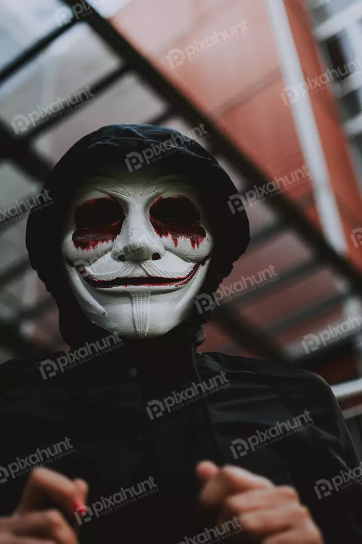 Free Premium Stock Photos a person wearing a white mask with a black hoodie