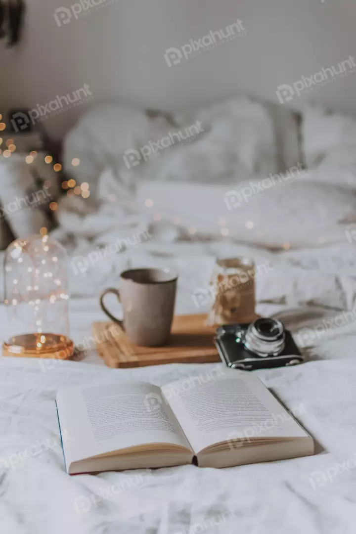 Free Premium Stock Photos A book with a cup of coffee, a camera, and a string of lights on a Bad