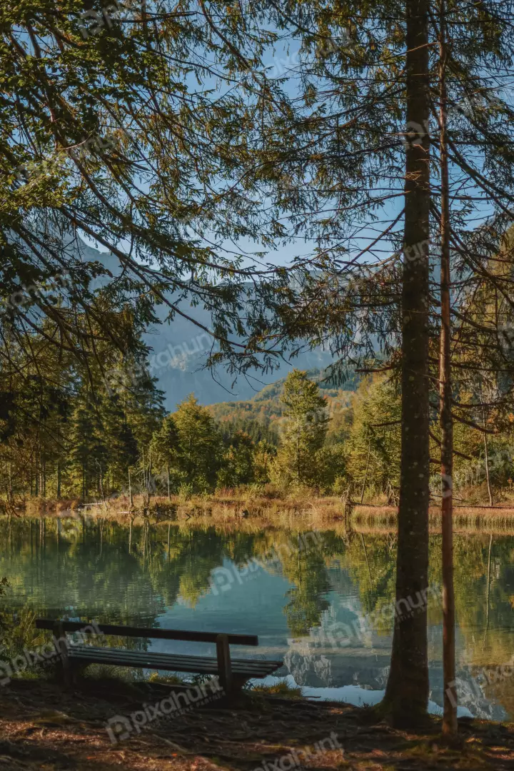 Free Premium Stock Photos A low angle, looking up at a bench in the foreground and a lake and mountains in the background