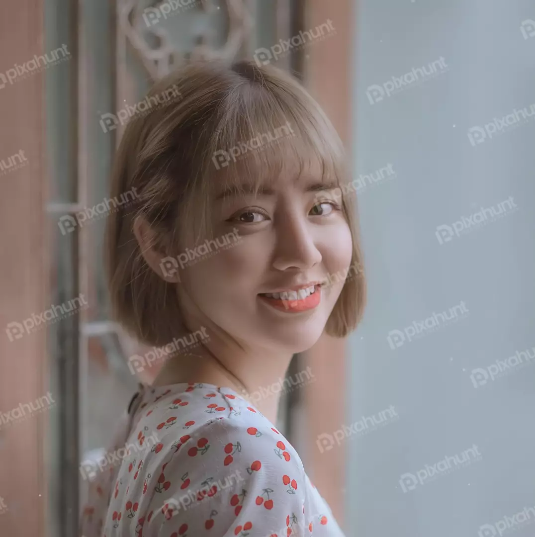 Free Premium Stock Photos Young Girl with short brown hair and a cherry-patterned dress is smiling and looking at the camera