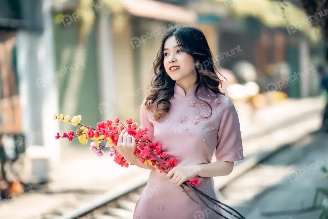 Free Premium Stock Photos A young woman model in a pink dress standing in a park, surrounded by trees and flowers