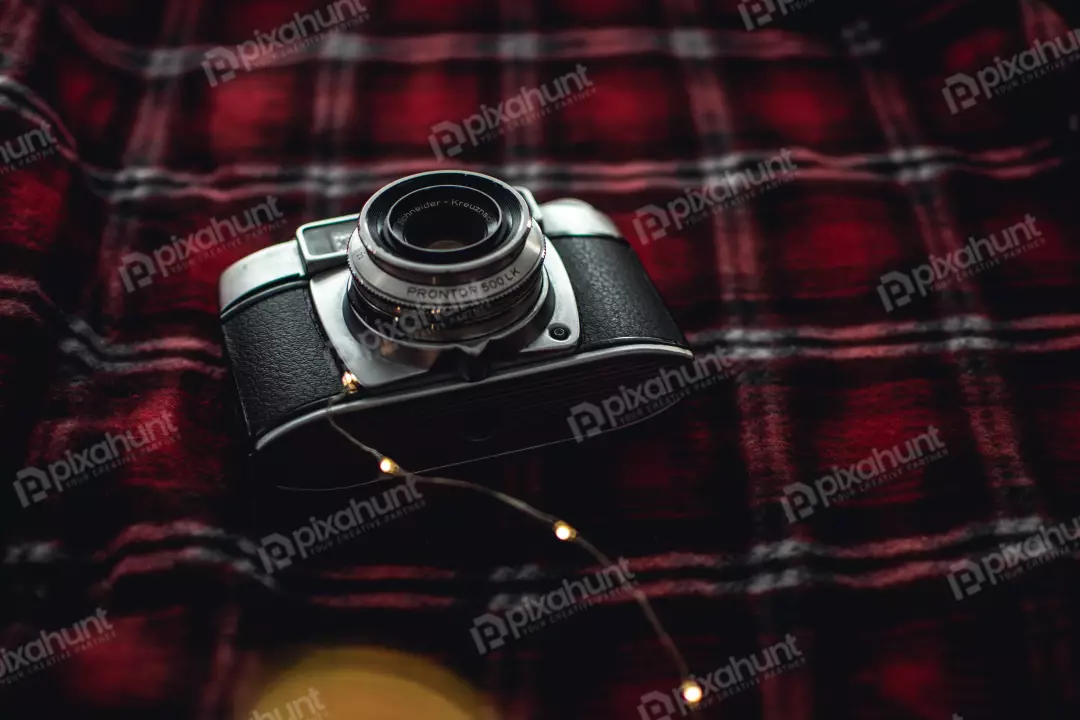 Free Premium Stock Photos a close-up of a vintage camera lying on a red and black checkered blanket