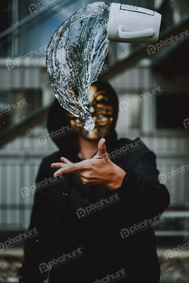 Free Premium Stock Photos holding a white cup in their right hand, and the cup is tilted at an angle so that the water inside is spilling out