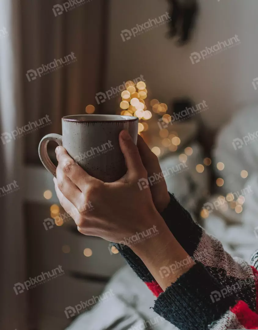 Free Premium Stock Photos looking up at a woman holding a mug of coffee in her hands