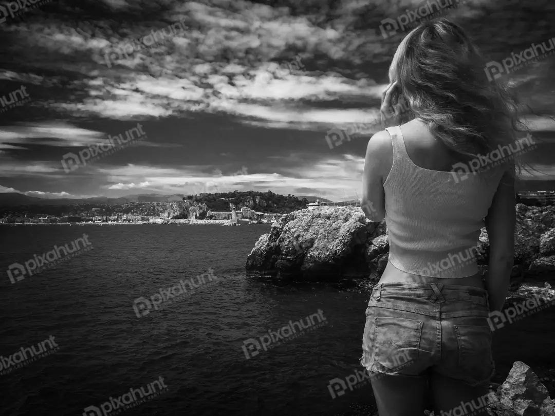 Free Premium Stock Photos Looking down on a woman standing on a rocky cliff