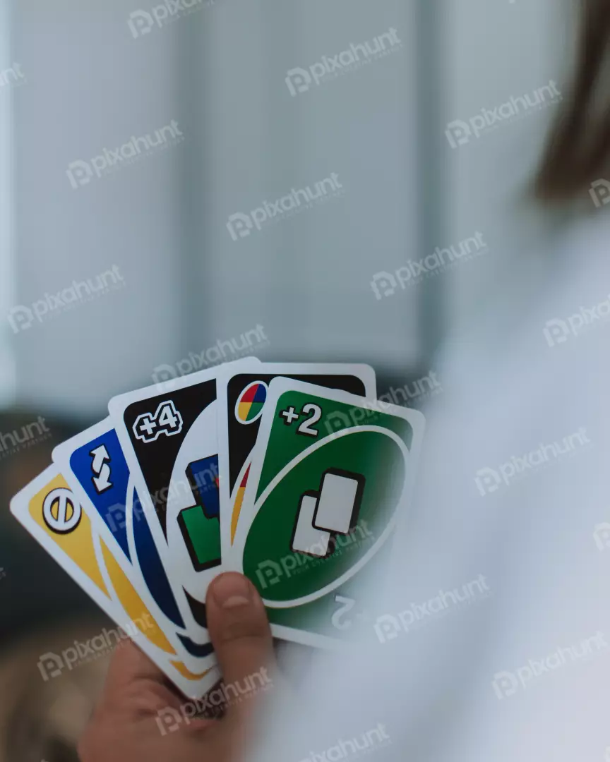 Free Premium Stock Photos uno cards are held in a person's hand and are facing the camera