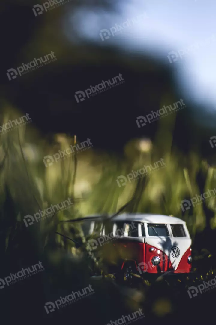 Free Premium Stock Photos a close-up of a red and white Volkswagen bus toy in a field of grass