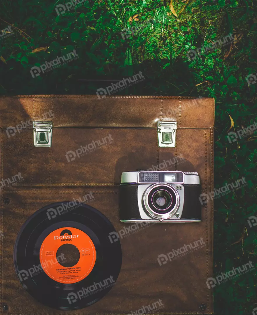 Free Premium Stock Photos A flat lay of a vintage camera and a vinyl record on a brown leather case