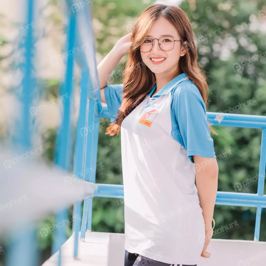 Free Premium Stock Photos A young woman standing in front of a blue railing ready for taking photo