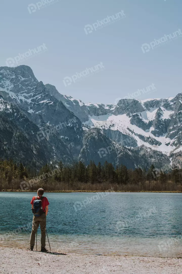 Free Premium Stock Photos looking up at a man standing on the shore of a lake