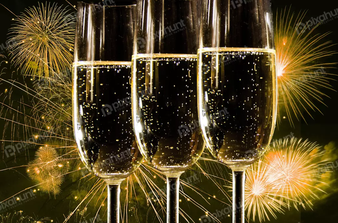 Free Premium Stock Photos Three champagne glasses with selective focus are filled to the brim with bubbly champagne against the backdrop of a dark sky lit up with fireworks