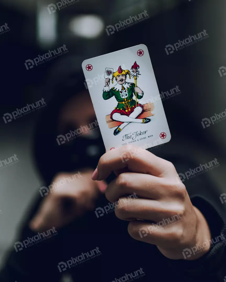 Free Premium Stock Photos a person holding a joker card