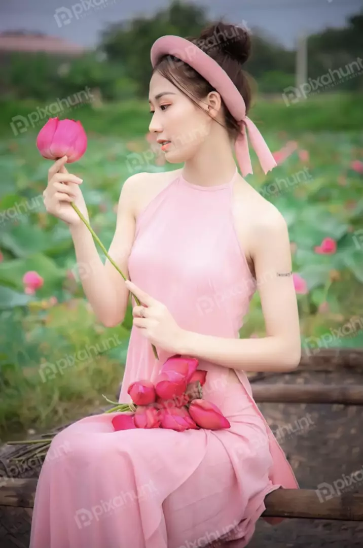 Free Premium Stock Photos A Girl in a pink dress sitting in a boat in a lake full of lotus flowers