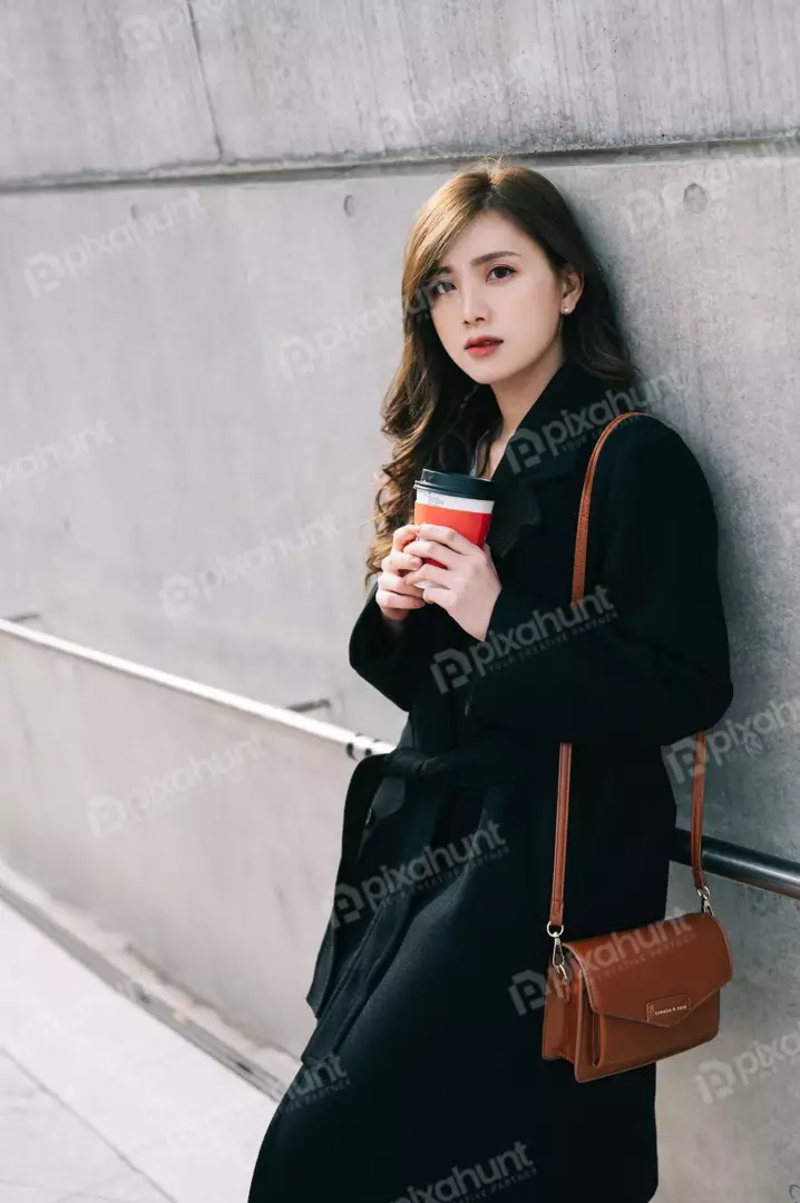 Free Premium Stock Photos A young woman standing in front of a concrete wall