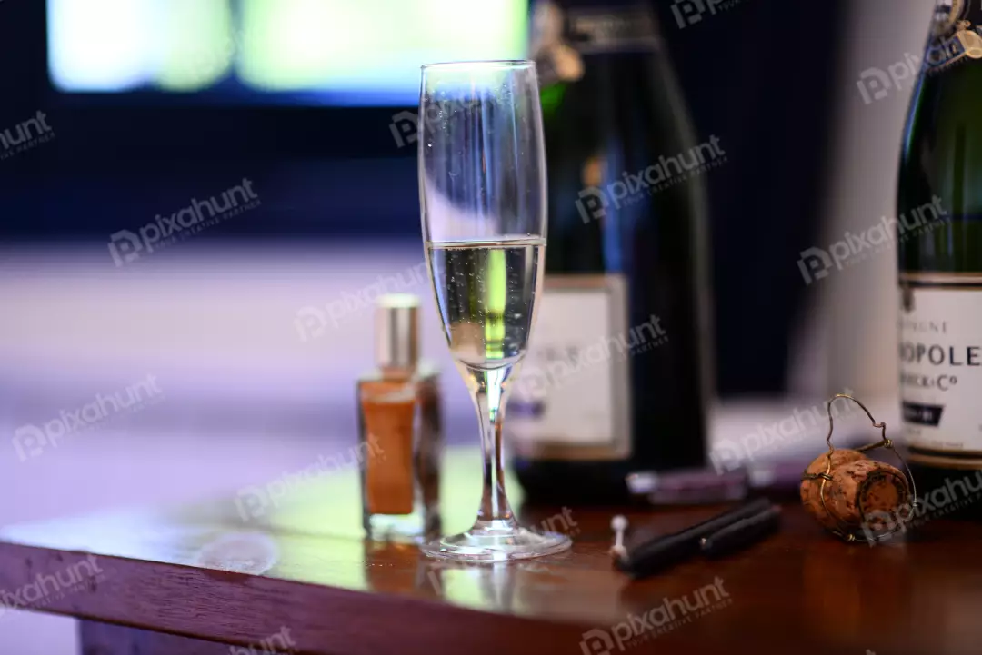 Free Premium Stock Photos a still life of a champagne glass, a bottle of champagne, a cork, a lighter and what seems like a perfume bottle