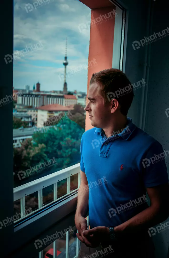 Free Premium Stock Photos The man is standing in front of a window, looking out at the city