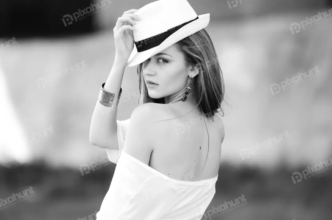 Free Premium Stock Photos A black and white portrait of a young woman And she wearing a white hat and a white shirt