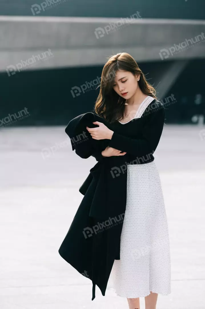 Free Premium Stock Photos A young woman in a white dress with black polka dots and has a sad expression on her face