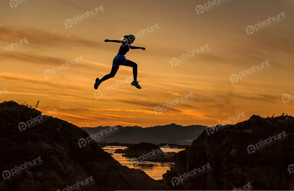 Free Premium Stock Photos A low angle, looking up at a woman who is jumping over a large rock