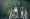 Two beautiful young women in traditional Thai clothing walking on a wooden bridge in a lush green forest