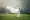 A beautiful young girl wearing a white dress and standing in a field of tall grass and the wind is blowing her hair and dress