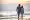 A beautiful  couple sunset on the beach walking hand-in-hand along the shore and the waves are gently lapping at their feet