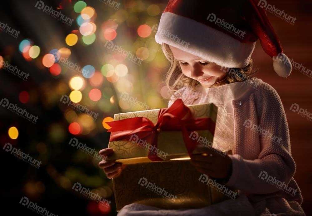 Free Download Premium Stock Photos | Little girl looking at open box with christmas present